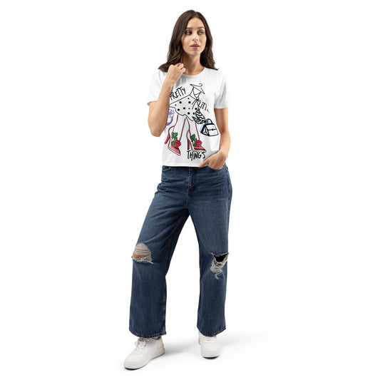 Woman wearing a Pretty Little Things Women's T-Shirt with a graphic design, paired with ripped wide-leg jeans and white sneakers, standing against a white background.