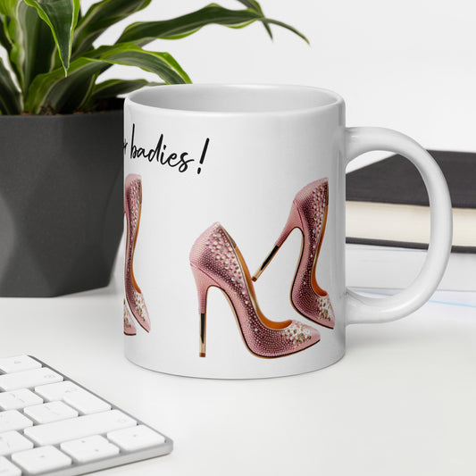 White glossy ceramic mug featuring pink high heels design and the text Mug – Life's Better in Pink Heels on a modern office desk with plant and keyboard, faith-inspired inspirational gift.