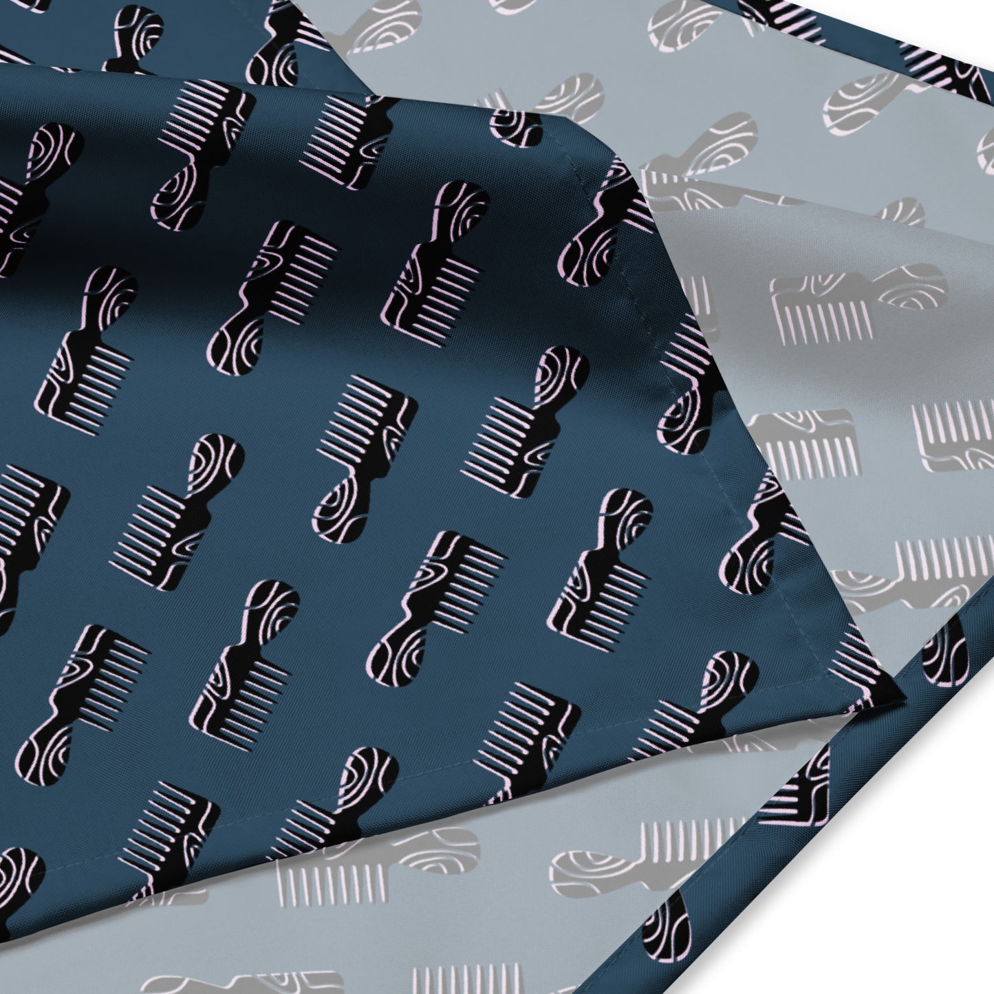 Close-up of a Mini Afro Combs All-Over Print Bandana featuring a repeating pattern of stylized afro combs in contrasting colors on a smooth fabric, highlighting its bold design and soft texture.