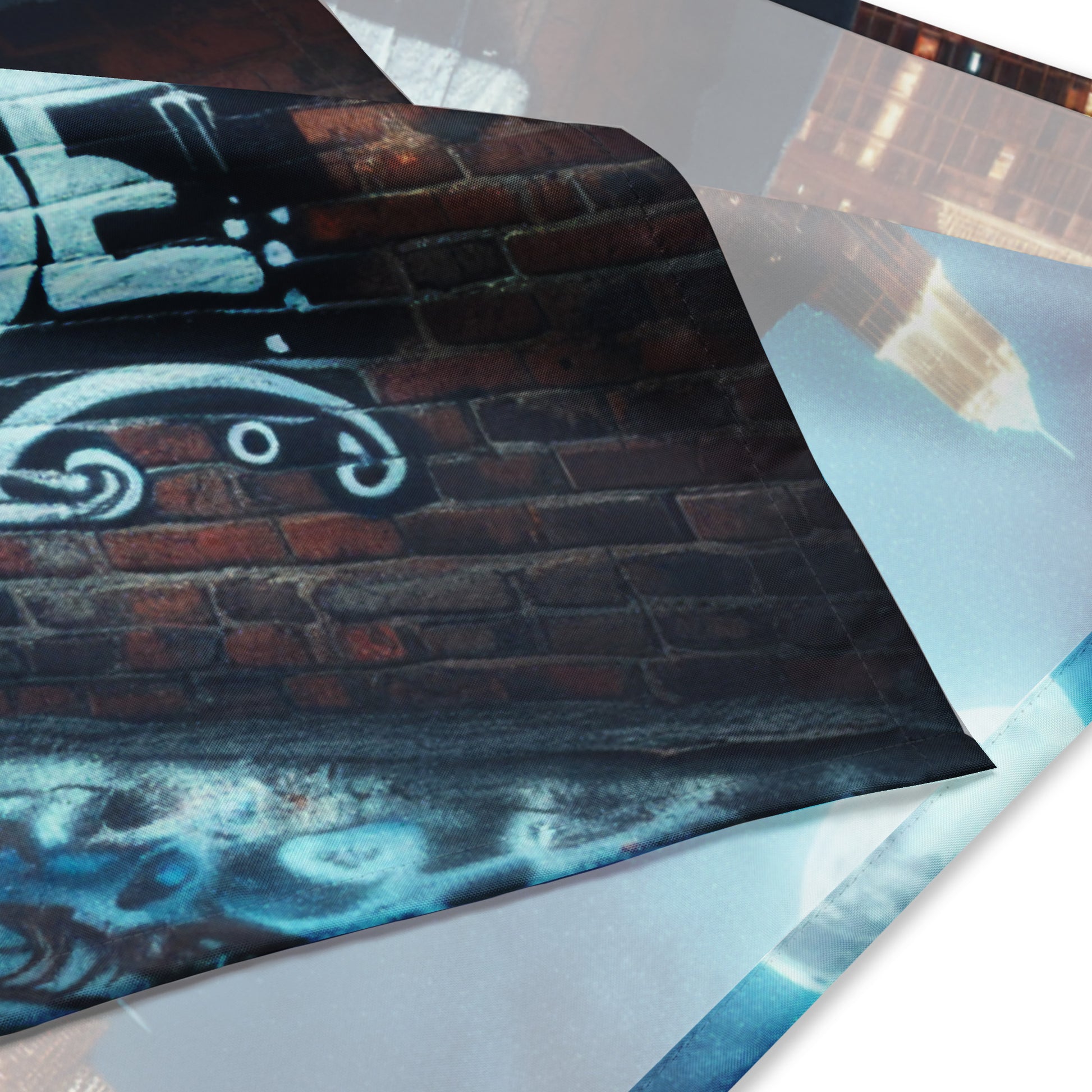 Close-up of the Moonlit Mural Bandana featuring a detailed urban mural design with brick textures and artistic white and blue graffiti elements on fabric.
