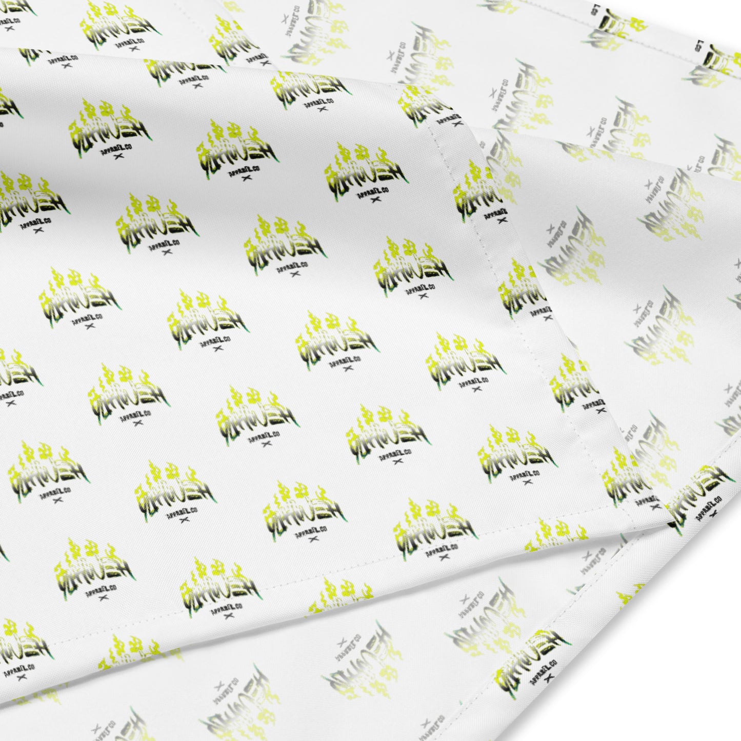 Close-up of white fabric with repeating yellow and black flame design and text patterns, part of the Yahweh Apparel Co. Bandana featuring faith-inspired apparel elements.