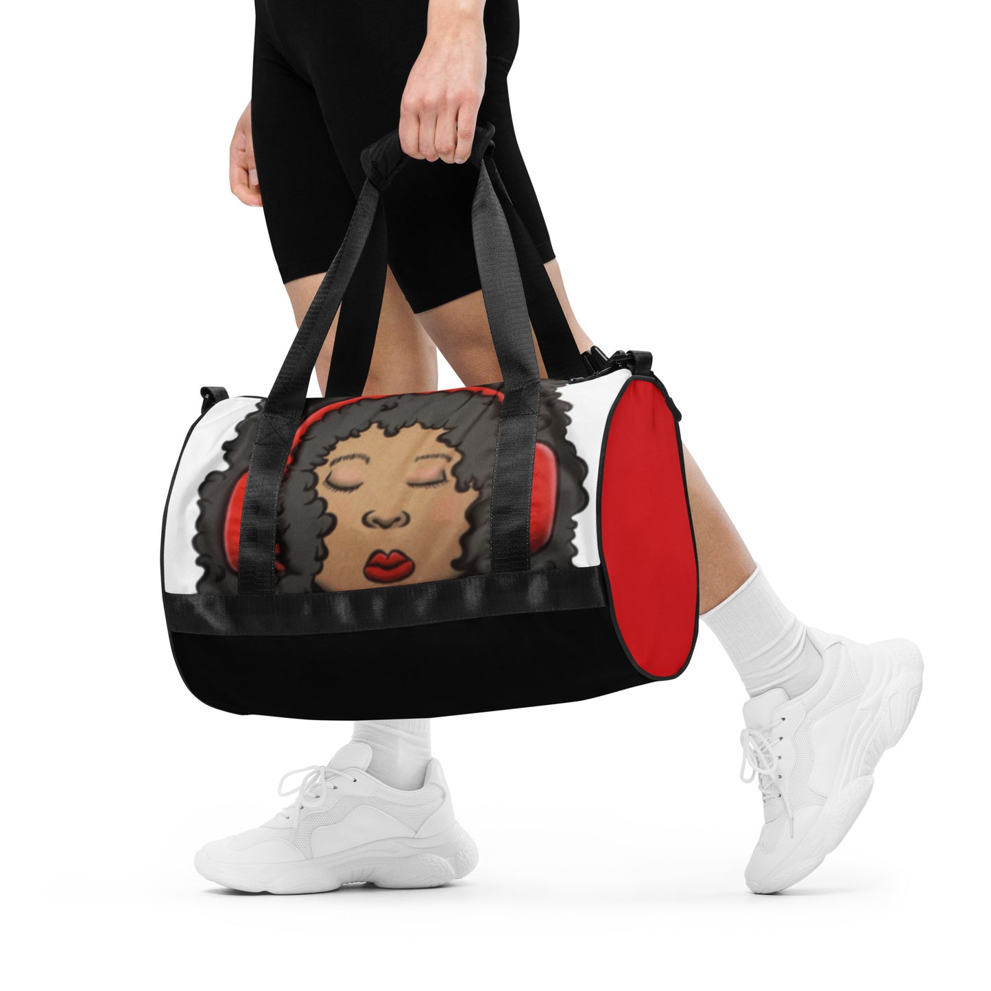Person carrying a Gym Bag – Issa Duffle featuring a printed design of a woman with curly hair wearing red headphones, with black straps and red accents on the sides.