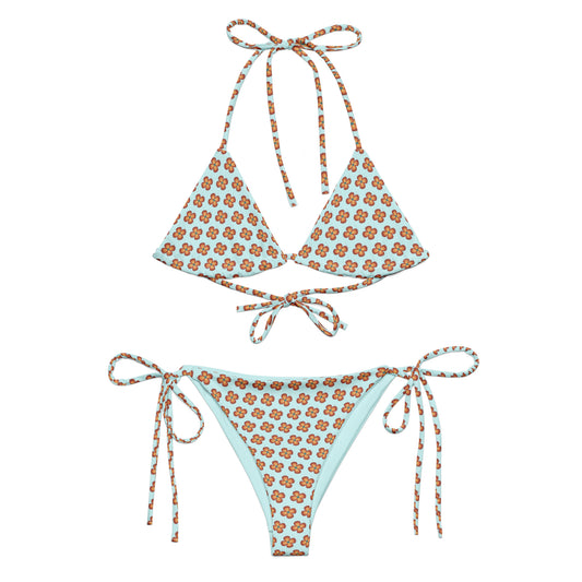 Garden Teal Recycled String Bikini with light blue fabric and orange floral print, featuring adjustable ties at the neck, back, and hips for a customizable fit.