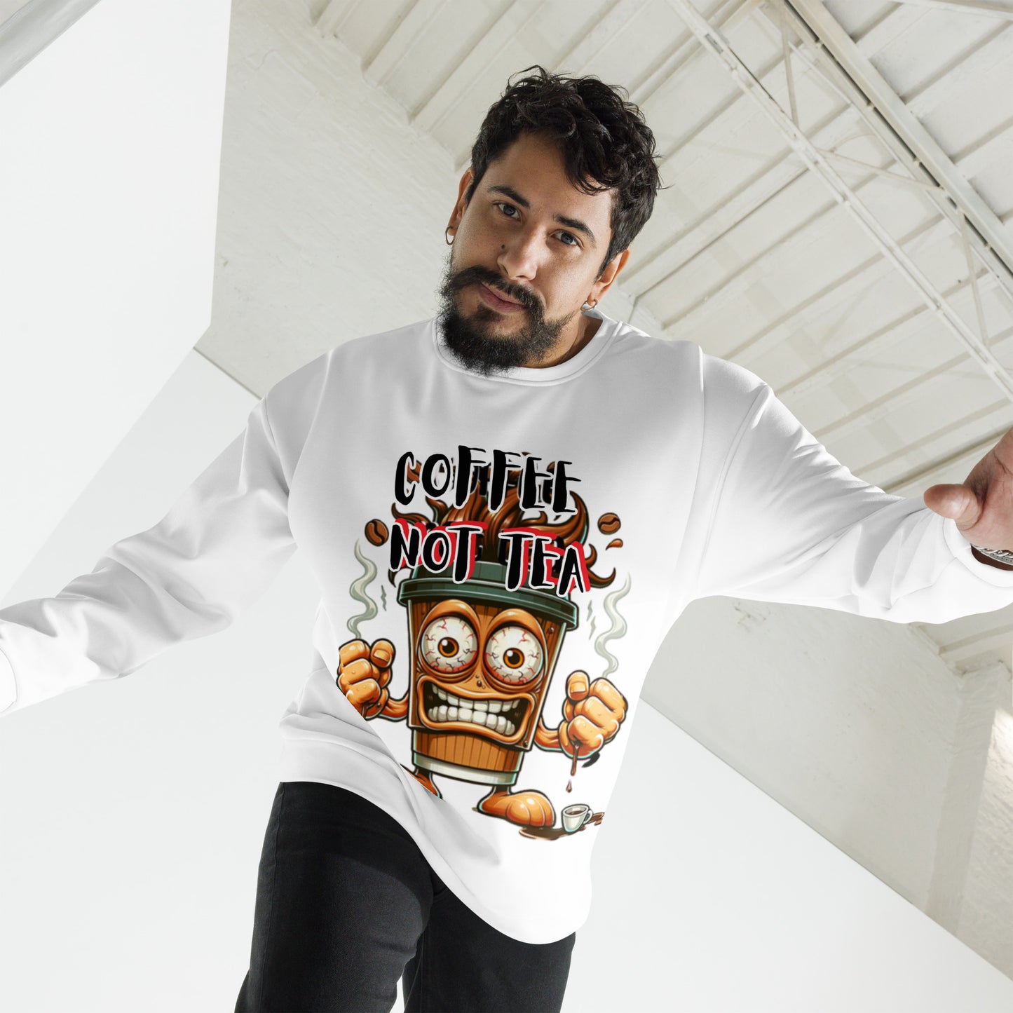 Man wearing a white Coffee Not Tea Sweatshirt featuring a bold graphic of an animated coffee cup with fists and steam, styled in a contemporary industrial space.
