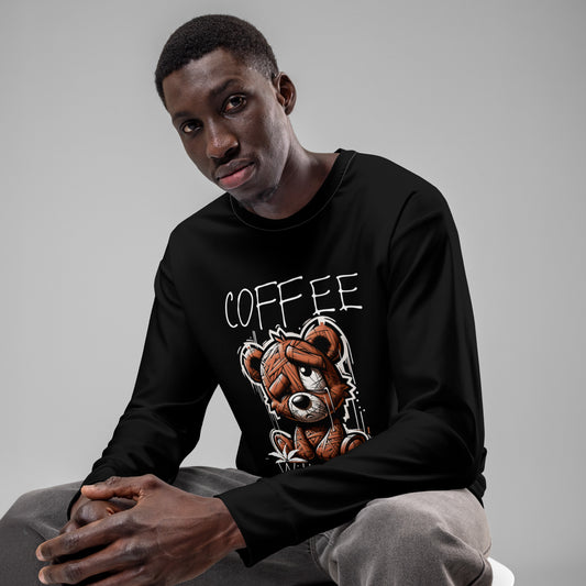Man wearing a black Coffee Withdrawal Premium Sweatshirt featuring a distressed teddy bear graphic, seated against a plain gray background in casual gray pants.