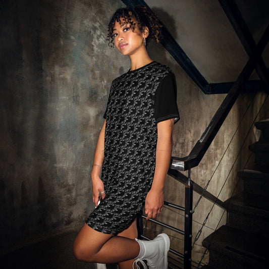 A woman modeling the Black & Gray Chain Loop T-Shirt Dress featuring a repeating chain pattern in a casual setting, paired with white sneakers.