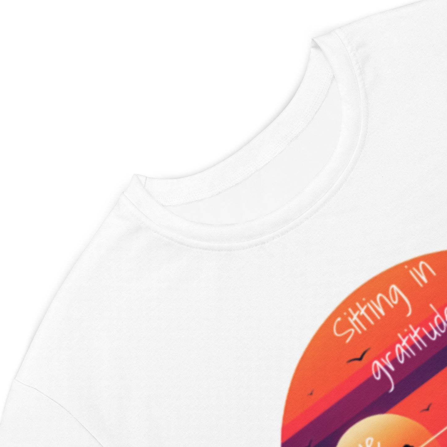 Close-up of a white Peace on the Water T-Shirt Dress featuring a colorful circular graphic with the phrase "Sitting in gratitude," showcasing faith-inspired apparel with purpose-driven messaging.