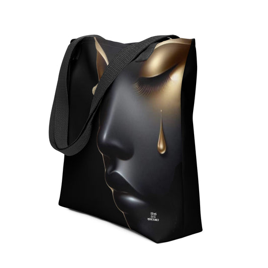 Black tote bag featuring a striking close-up of a serene face with gold tear and eye detail, combining melanin-rich imagery with purpose-driven messaging in Tote Bag – Still She Rises.