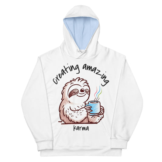 White hoodie – Let Karma Handle It with a cute sloth holding a steaming blue mug and the phrase "Creating amazing karma," blending melanin-rich imagery with purpose-driven faith-inspired apparel.