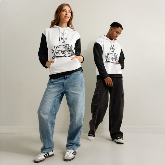Two models wearing "Is It Friday Yet? Bandaged Cat Unisex Cotton Hoodie" in white with black sleeves, styled casually with jeans and cargo pants in a minimal indoor setting.