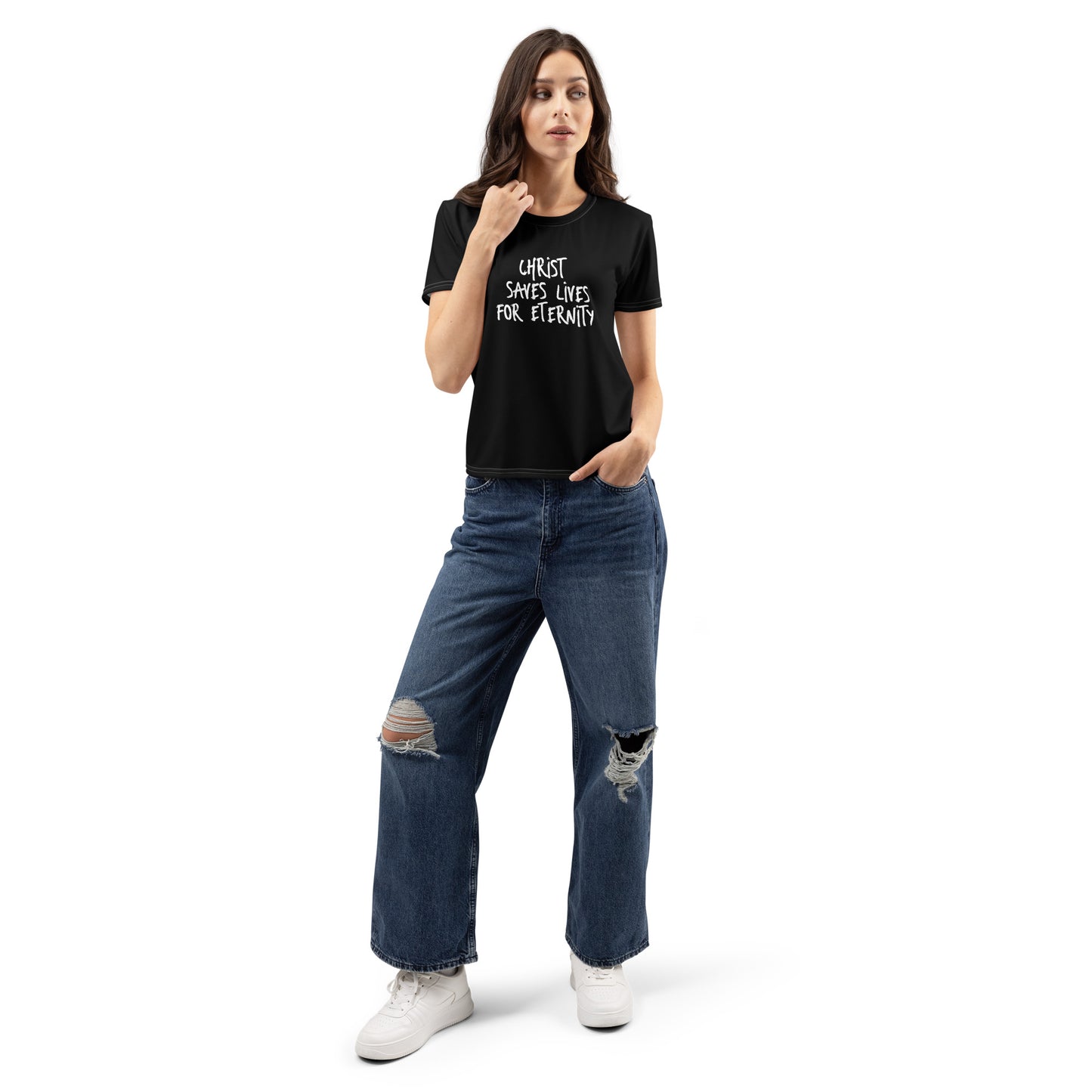 Woman wearing a black Women's T-Shirt – Christ Saves Lives for Eternity with white text, paired with ripped blue jeans and white sneakers, standing against a white background.