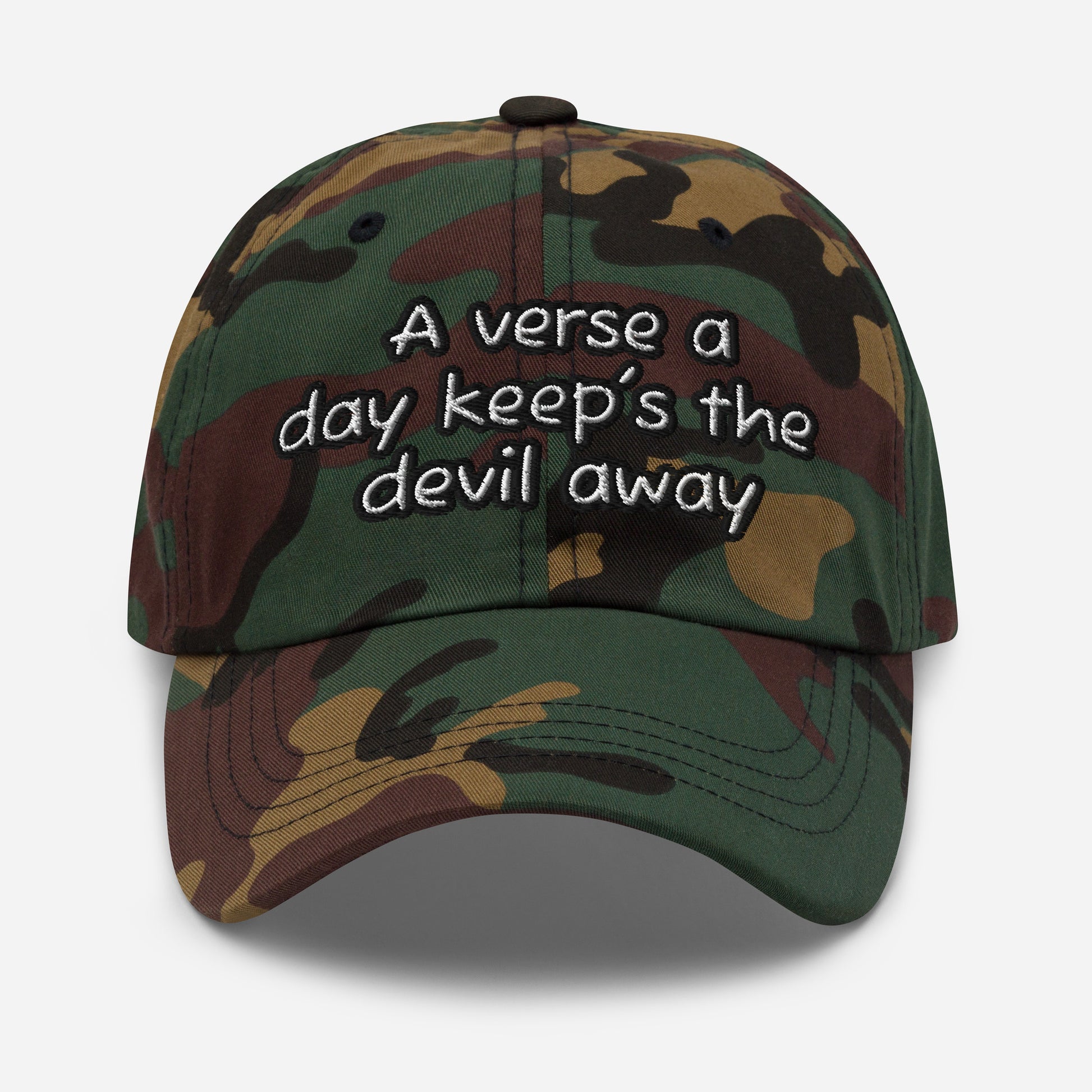 Dad Hat – A Verse a Day Keeps the Devil Away featuring a green and brown camouflage pattern with embroidered motivational text on the front, blending faith-inspired apparel with classic style.