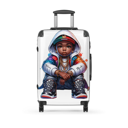 Nelli Rock Hard-Shell Suitcase featuring a detailed graphic of a stylish young Black child in a hoodie, sneakers, and layered gold chains, combining melanin-rich imagery with purpose-driven messaging.
