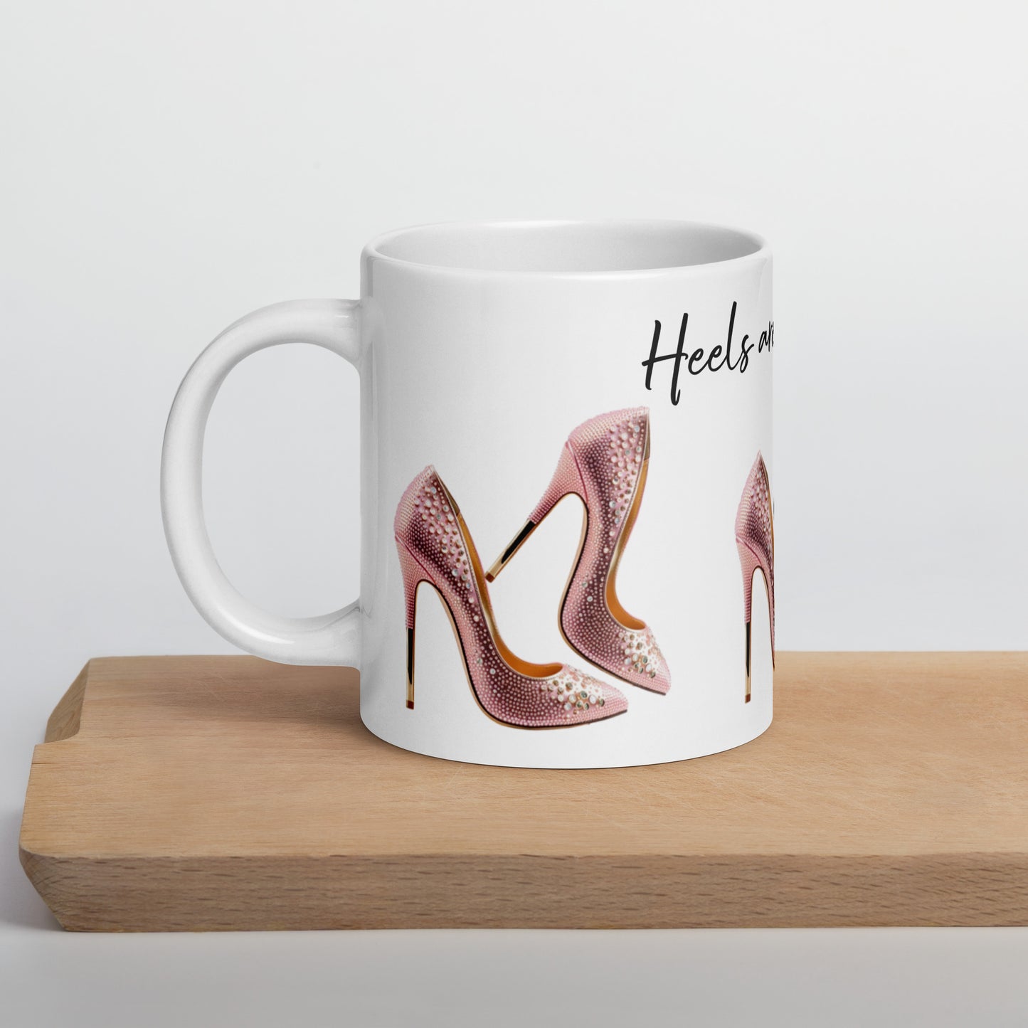 White glossy ceramic mug with an image of pink embellished high heels and the phrase Mug – Life's Better in Pink Heels, featuring faith-inspired, purpose-driven messaging.