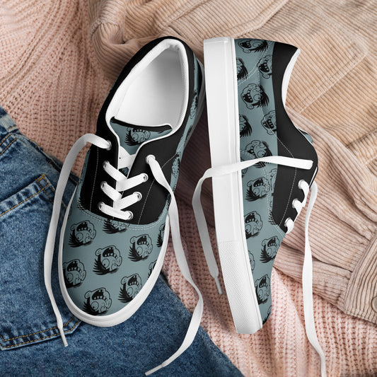 Pair of Cartoon Face Women's Lace-Up Canvas Shoes in black and gray with a repeated cartoon face pattern, styled casually with denim and knitwear background.